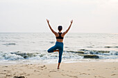 Frau am Strand beim Yoga