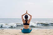 Woman on beach doing yoga