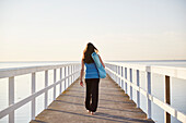 Frau spaziert auf Pier am Meer