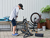 Boy inflating bicycle tire