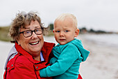 Portrait of grandmother carrying grandson