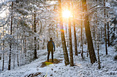 Mann geht im Winterwald spazieren