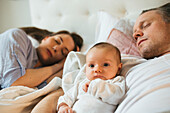 Parents with baby in bed
