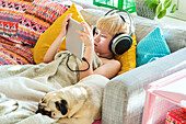 Junge mit digitalem Tablet auf dem Sofa