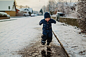 Baby boy walking on street in winter