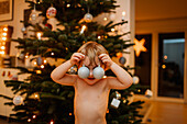 Boy playing with Christmas ornaments