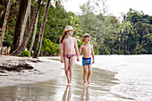 Boy and girl walking on beach