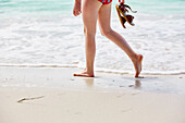 Child walking on sandy beach