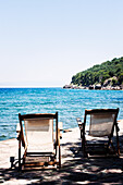 Sunchairs on sandy beach