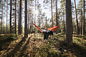 Young couple lying in hammock in forest