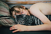 Junge schläft mit Katze