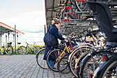 Woman taking bicycle from parking