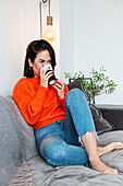 Woman having coffee on sofa