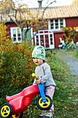 Toddler girl carrying ride-on bike