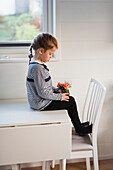 Girl sitting on table with flowers