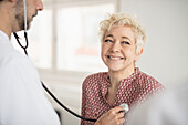 Doctor with stethoscope examining patient