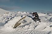 Pärchen mit Blick auf Telefon im Winter