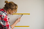 Woman hammering nails into wall