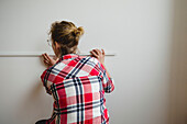 Woman measuring wall