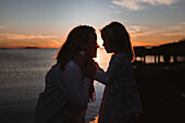 Silhouettes of mother and daughter at sunset