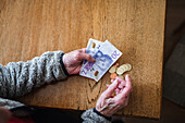 Hände halten Geldscheine und Münzen