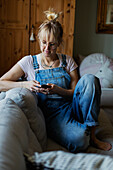 Woman using phone on sofa