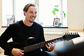 Lächelnder Mann spielt E-Gitarre