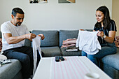 Father and teenage daughter folding clothes