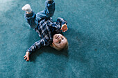 Junge hat Spaß auf Teppich