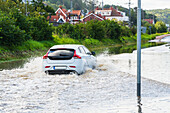Auto fährt durch überschwemmtes Gelände