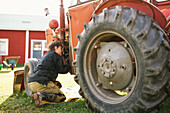Frau repariert Traktor