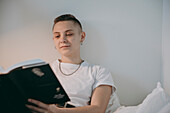 Young woman reading in bed