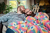 Male couple sleeping on sofa