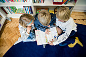 Kids looking at book together