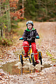 Boy cycling through forest