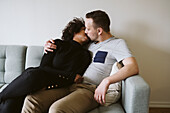 Couple kissing on sofa