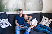 Male couple relaxing on sofa