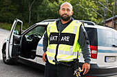 Portrait of security guard with car in background