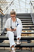 Female sitting on stairs while using cell phone