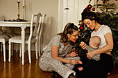 Mothers with baby near Christmas tree