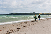 Frauen, die am Strand spazieren gehen