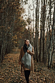 Frau spaziert durch Herbstwald