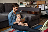 Vater liest Baby ein Buch vor