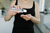 Frau trägt Händedesinfektionsmittel auf ihre Hände auf