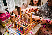Mother and daughter using loom