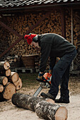 Senior man using chainsaw