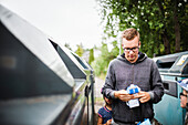 Man standing near recycling bin