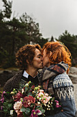 Lesbisches Paar küsst sich im Freien