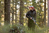 Woman with riffle in forest
