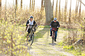 Couple cycling through forest